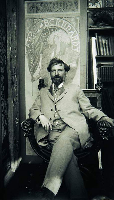 Mucha seated in front of his epoch-making poster of Sarah Bernhardt Mucha seated